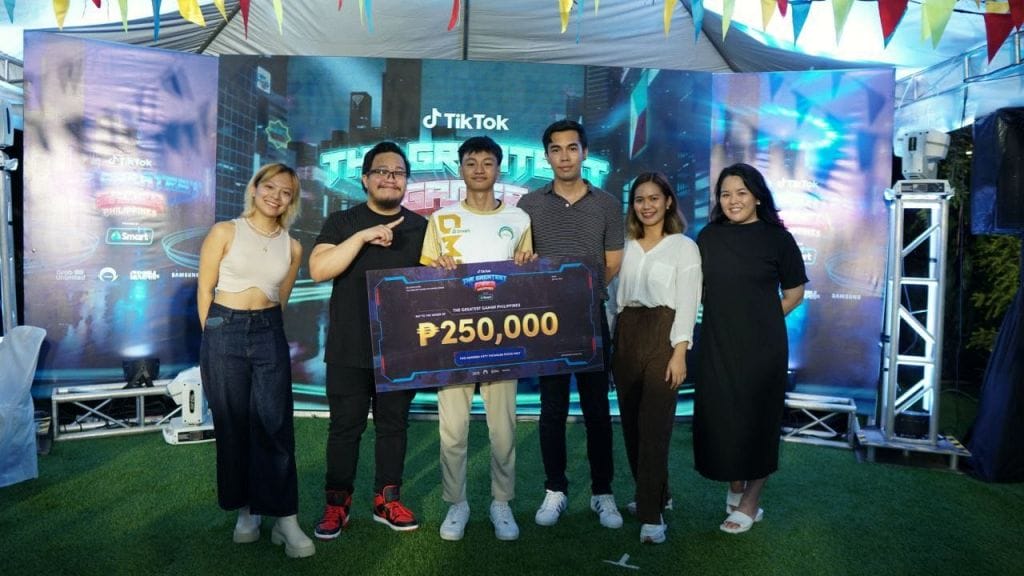 Presenting the cash prize during The Greatest Gamer Philippines finale are, from left: Mafe Sanchez, TikTok Operational Specialist - Sports & Gaming; Emmanuel John Castro, TikTok Sports & Gaming Vertical Manager; Winner Ezequiel "Spidey" Cauilan; Robi de Guzman, TikTok SEA Marketing Manager; Rhodelyn Mae Jacinto, TikTok Content Programming; Bea delos Reyes, TikTok SEA Social